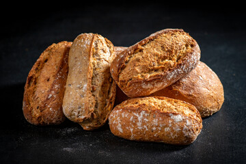 Fresh rolls on a black kitchen table. Bread prepared for serving.