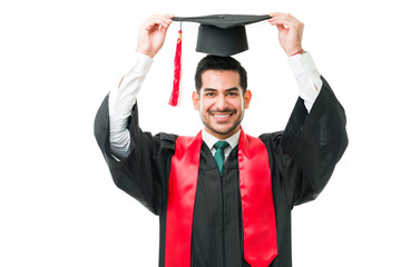 Excited young man getting dressed for his graduation ceremony