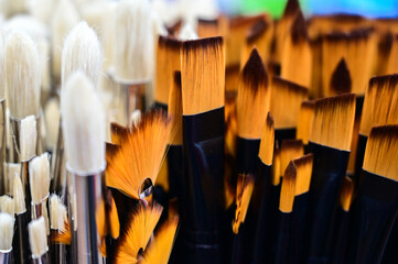 Stunning and sophisticated paint brushes in the shop. Natural squirrel brushes of different forms and sizes. Artist's tools on the blurred background. Black and white brushes.