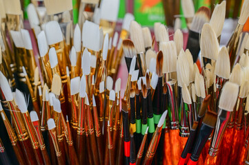 Stunning and sophisticated paint brushes in the shop. Natural squirrel brushes of different forms and sizes. Artist's tools on the blurred background. Black and white brushes.