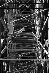 Black and white construction of the Ferris wheel from the inside. Industrial composition of metal architecture beauty. Abandoned damn wheel.