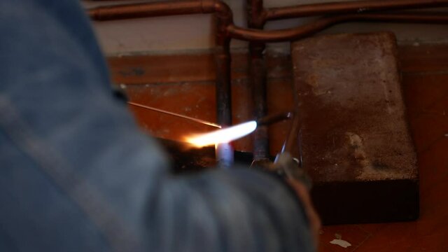 Close-up of autogenous welding of copper pipe, urgent repair welding of malfunctional home central heating system