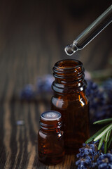 Dripping Lavender essential oil from pipette into glass bottle