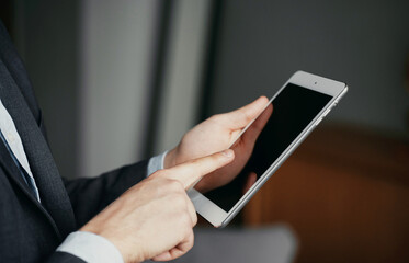 it is used on a modern tablet. male hands near the monitor, typing a message