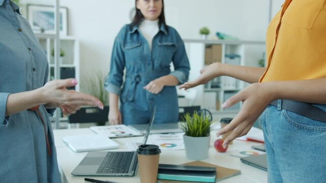 Slow motion close-up of women's handshake expressing agreement in office room while ladies are making deal sorting out differences. People and unity concept.
