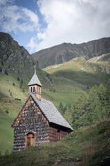 small chapel in the mountains on a cloudy day