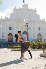 Obraz premium Hispanic couple in love in front of the San Jose cathedral in Antigua Guatemala - Young tourists enjoying their vacations in the colonial city on a sunny day - Couple having fun in the park