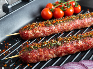 lula kebab raw beef lamb on frying pan grill, spices, top view, close up