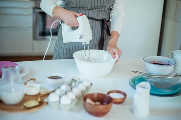 Young beautiful woman bakes a cake. Sweets. Confectionery.