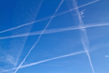 Crossing contrails from airplanes on blue sky