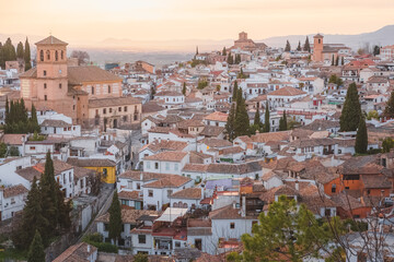Fototapeta na wymiar Old town sunset or sunrise cityscape view of terracotta rooftops and the Church of San Salvador in the historic Moorish or Arab Quarter (albaicin) in Granada, Andalusia, Spain.