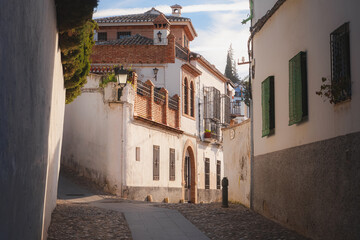 Traditional Moorish architecture on a quiet and quaint narrow cobblestone street in old town (Albaicin or Arab Quarter) Granada, Spain, Andalusia.
