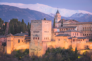 Classic view at night of Charles V Palace, the iconic Alhambra and Sierra Nevada Mountains from Mirador de San Nicolas in the albaicin old town of Granada, Andalusia, Spain.