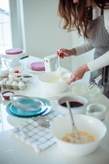 Young beautiful woman bakes a cake. Sweets. Confectionery.