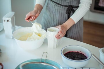 Young beautiful woman bakes a cake. Sweets. Confectionery.