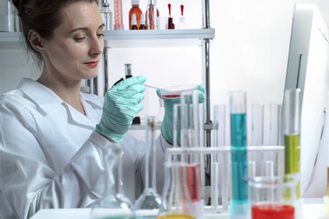 Active lady scientist makes bacteriological inoculation in a petri dish with a glass stick in a...