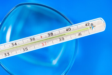 The medical thermometer shows a high body temperature of 39.5 degrees Celsius. Illness, fever, flu.