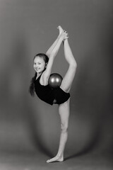 Young girl doing gymnastics over grey background