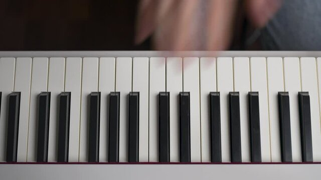 Camera Sliding Over Hands Playing Piano