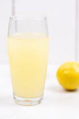 Homemade Lemonade in the glass with lemons on the table