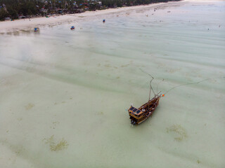 Aerial Shot Low Tide in Paje and Jambiani on Zanzibar, Tanzania. Stranded Ships on a Shallow Indian Ocean Shoal five kilometers of Wavy Sandy Shelf