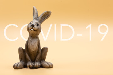 Easter bunny on green background with the inscription covid-19 at Easter in times of corona and pandemic without family