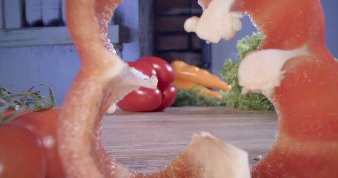 Cooking pepper salad in the kitchen. Cutting red vegetarian fresh and dietary pepper vegetables into pieces. Cinematic 4K slow motion.
