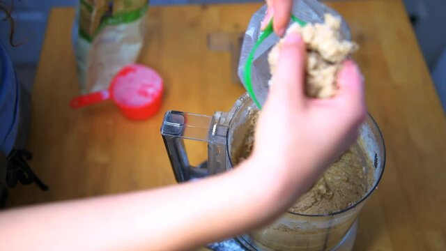 Hand forming homemade bird feeder suet of white organic flour, mealworms, raw peanuts and peanut butter extra virgin coconut oil from food processor into zipper reusable re-sealable plastic bag