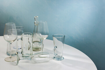 Glass transparent barware stands on a white table.