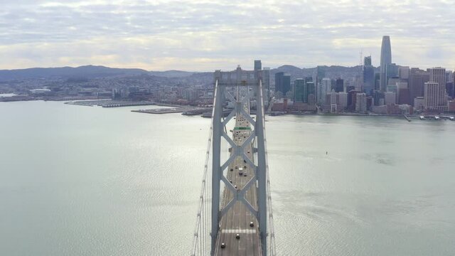 Aerial: drivers crossing the bridge towards the city, drone view