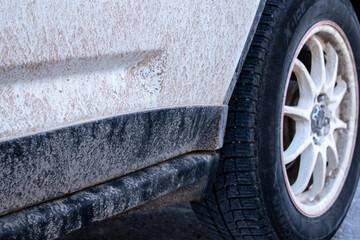 Muddy snow tires on a white SUV, white rim and slight vignette, Toronto, Ontario, Canada, February...