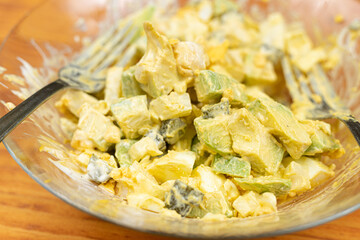 Served Avocado salad with Eggs and Pickles