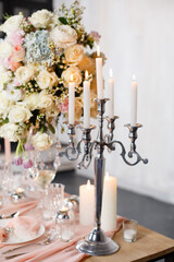 Beautiful candy-bar for wedding or birthday celebration. Gentle pink color. Beautifully served table with candles and fresh flowers with tender pink color