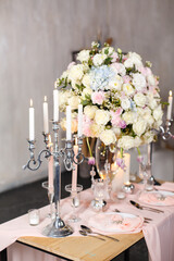 Beautiful candy-bar for wedding or birthday celebration. Gentle pink color. Beautifully served table with candles and fresh flowers with tender pink color