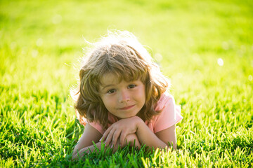 Child in park outdoor. Spring kid lying on grass. Summer boy walk. Children adaptation.