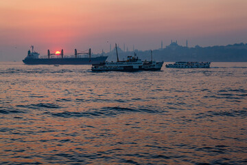 Fototapeta premium Ships against the old city at sunset on the Bosporus, Istanbul, Turkey.