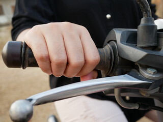 closeup of woman hand on handle motorcycle bar.
