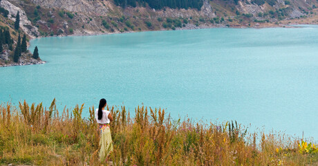 Woman with Trans-Ili Alatau mountains, Big Almaty Lake, Kazakhstan