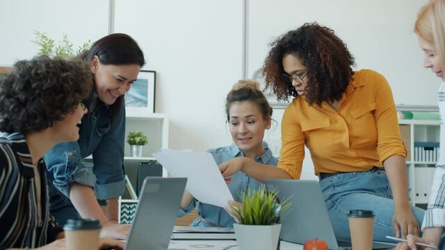 Slow motion of smart female office workers talking and working with laptop sharing ideas brainstorming at work. Business communication and lifestyle concept.