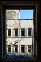 Ukraine, Pripyat, Chernobyl. Looking through a broken window from one abandoned building to another.