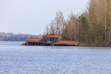 Ukraine, Pripyat, Chernobyl. Abandoned houseboat and restaurant in lake.