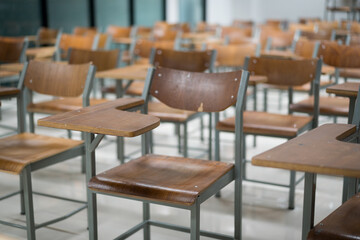Wooden chairs are well arranged in the classroom. Empty classroom with vintage tone wooden chairs. Back to school concept..