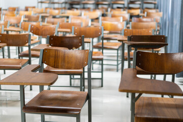 Wooden chairs are well arranged in the classroom. Empty classroom with vintage tone wooden chairs. Back to school concept..