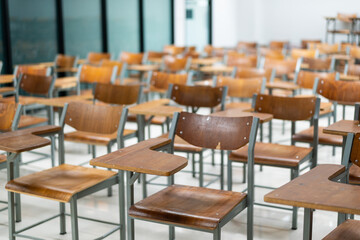 Wooden chairs are well arranged in the classroom. Empty classroom with vintage tone wooden chairs. Back to school concept..