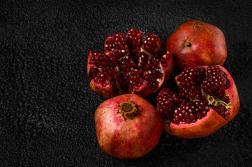 Close-up of the two halves of a pomegranate fruit with a ripe pomegranate grains. Next to the two...