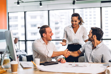 Image two business partners successful handshake together in front of teamwork casual business winning success agreement in modern office.Partnership approval and teamwork