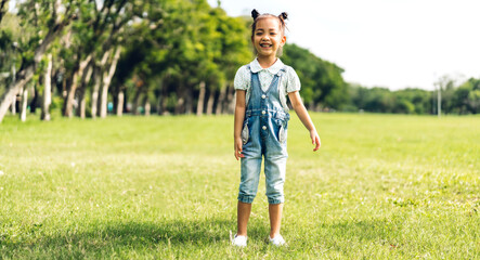 Portrait of asia happy little cute girl smiling and looking at camera in the park