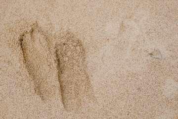 Beautiful white sand beach texture background with two footprints