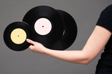 Vinyl records in female hand on the gray background.