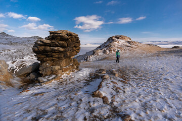 A tourist walks among the rocks on Oltrek island